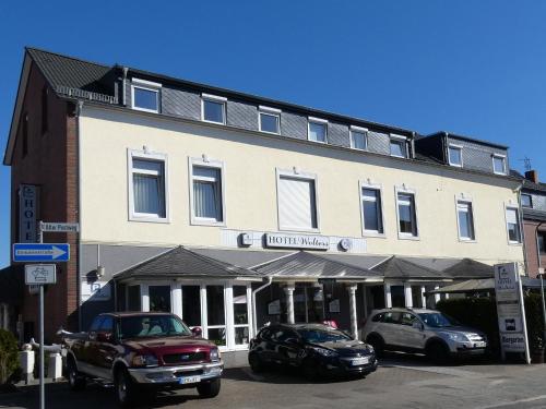 un edificio con dos coches estacionados frente a él en Hotel Wolters en Bremen