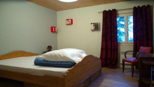 a bedroom with a bed and a window at Le chalet de CLEM & SAND in Saint-Riquier-ès-Plains