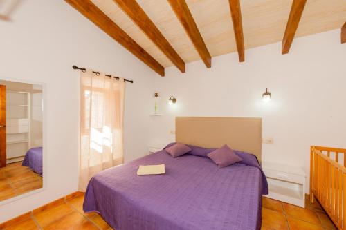 サン・リョレンツ・デス・カルダサルにあるFinca Cas Padrí Martetのベッドルーム(紫色のベッド、本付)