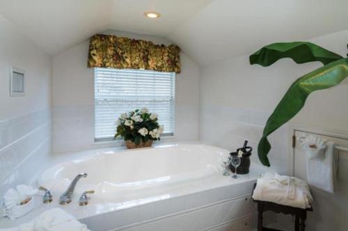 The Cozy Inn في سانت أوغيستين: حمام أبيض مع حوض استحمام ونافذة