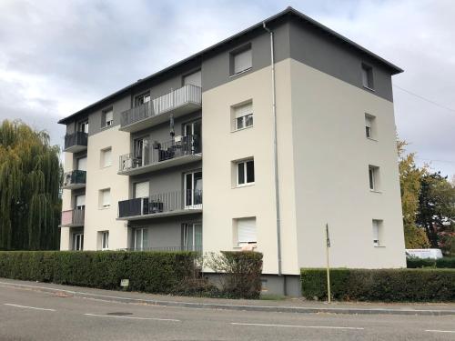 a large white building with balconies on a street at F1 Terrasse LED, Colmar à 5min, calme in Wintzenheim