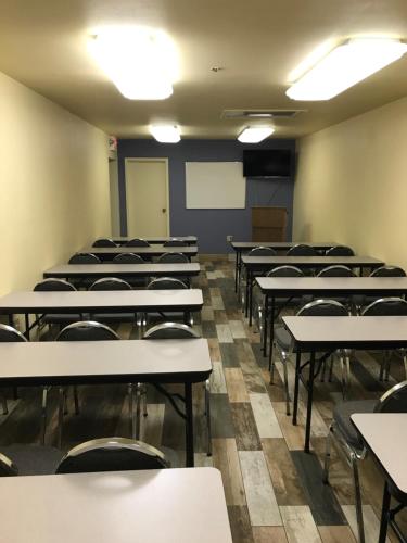an empty classroom with rows of tables and chairs at Days Inn by Wyndham N Orlando/Casselberry in Orlando