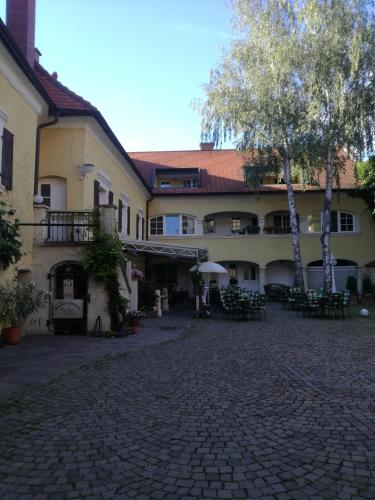 un edificio con mesas y sillas en un patio en Rathausstüberl, en Bad Radkersburg