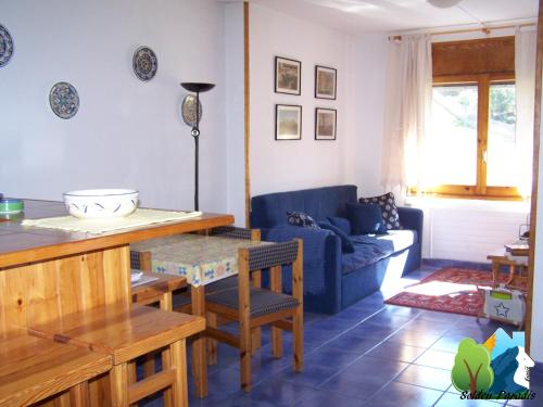 sala de estar con mesa y sofá azul en Soldeu Paradis Incles, en Incles
