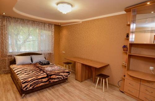 a bedroom with a bed and a desk in it at Апартаменты Deluxe in Cherkasy