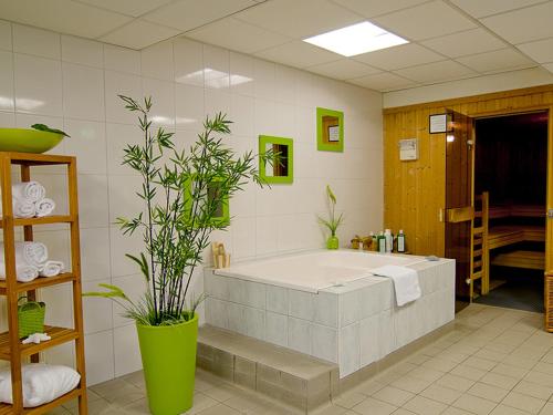 a bathroom with a large tub with a plant at ACHAT Hotel Bochum Dortmund in Bochum