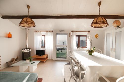 uma sala de estar com uma grande mesa branca e cadeiras em Casa do Mar | Sea House | Apúlia em Apúlia