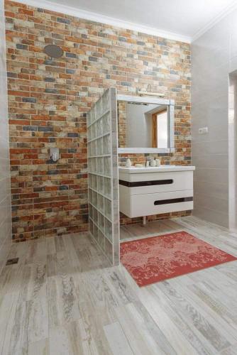a bathroom with a mirror and a brick wall at Бутик 2017 in Bilhorod-Dnistrovskyi