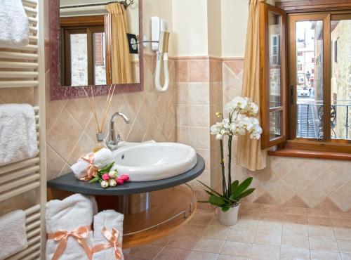 bagno con lavandino e specchio di Boutique Hotel al Grappolo d'Oro a Torgiano