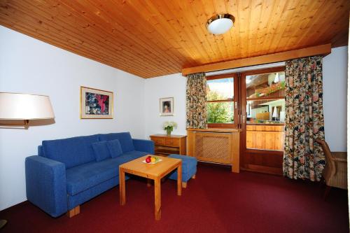 a living room with a blue couch and a table at Felbermayer´s Bed & Breakfast in Gaschurn