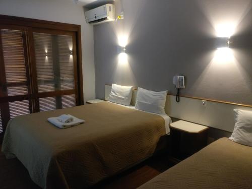 Habitación de hotel con 2 camas y toallas. en Sítio Hotel e Eventos, en Sao Pedro do Sul
