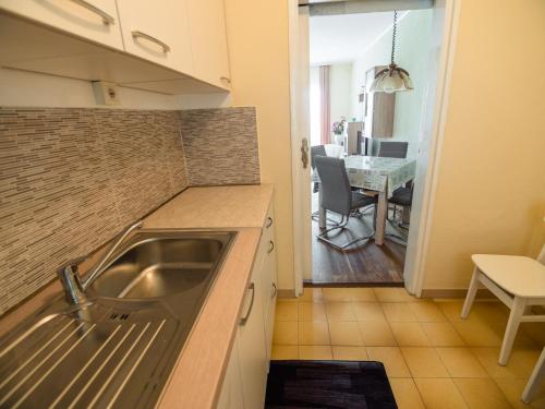 a kitchen with a sink and a dining room at 689 Banjol in Rab