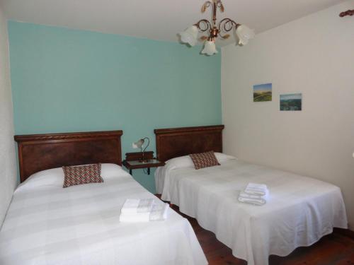 two beds in a room with blue walls at Casa Rural Etxaluze in Ormáiztegui