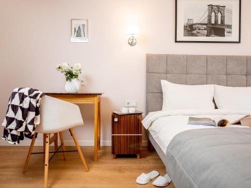 a bedroom with a bed and a desk and a chair at Art Deco Central Rooms in Lviv