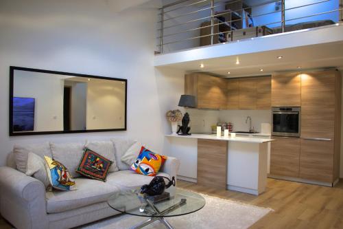 un salon avec un canapé et une cuisine dans l'établissement DUPLEX FONTAINE - Appartement Duplex coeur vieil Antibes Old city Marché provencal, à Antibes