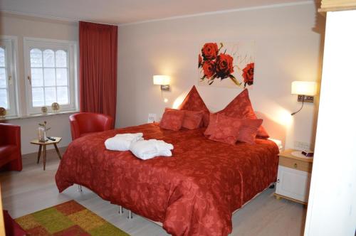 バート・ベヴェンセンにある5***** Luxus Suite Engelのベッドルーム1室(赤いベッド1台、タオル2枚付)