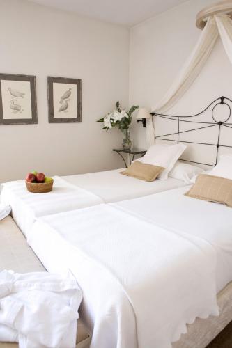 two beds in a bedroom with white walls at Palacio De Los Navas in Granada