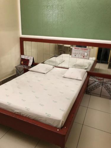 a bed with two pillows on it in a room at Motel Coimbra (Adults only) in Belo Horizonte