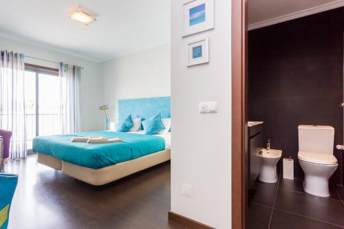 ラゴスにあるLagos Marina apartment with pool & gymのベッドルーム(青いベッド1台、トイレ付)