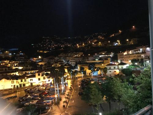 Una ciudad de noche con coches estacionados en un estacionamiento en Estudio Laura en Palmeira