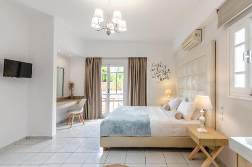 a white bedroom with a bed and a bathroom at Vergina Studios & Apartments in Malia