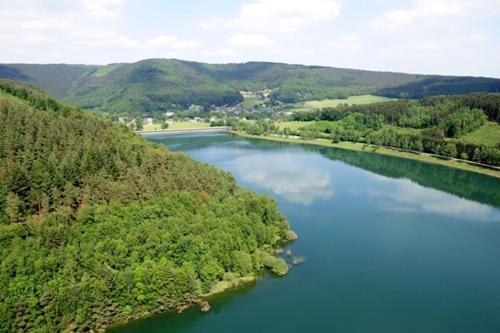 an aerial view of a river with trees and mountains at Le Coffee Ride Cycling Cafe in Stavelot