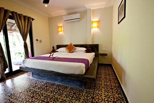 a bedroom with a large bed in a room at Raingsey Bungalow in Kep