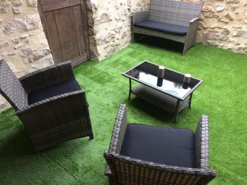eine Terrasse mit Stühlen, einem Tisch und einem Tisch in der Unterkunft La maison bleue in Nogent-sur-Seine