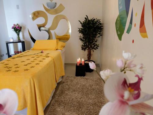 a bedroom with a bed with a yellow blanket and flowers at Hotel Rincon Aleman in Riobamba