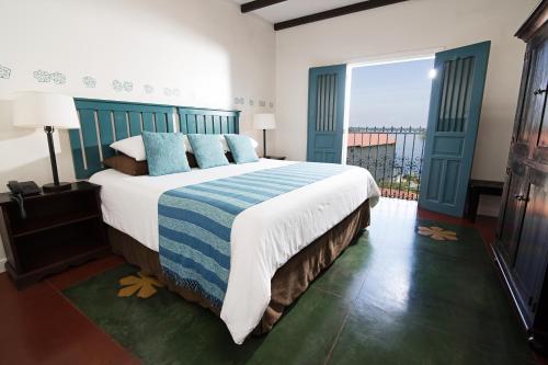 a bedroom with a large bed and a large window at Hotel Isla de Flores in Flores