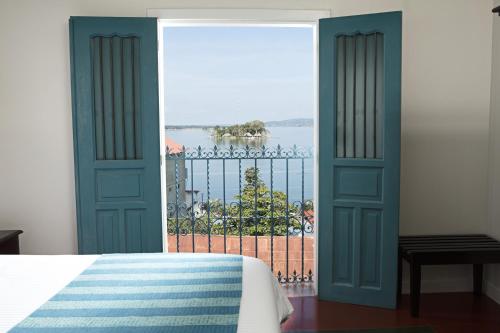 a bedroom with a window with a view of the ocean at Hotel Isla de Flores in Flores