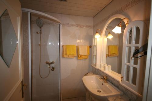 ein Bad mit einer Dusche, einem Waschbecken und einem Spiegel in der Unterkunft Appartement am Schilift in Sankt Gilgen