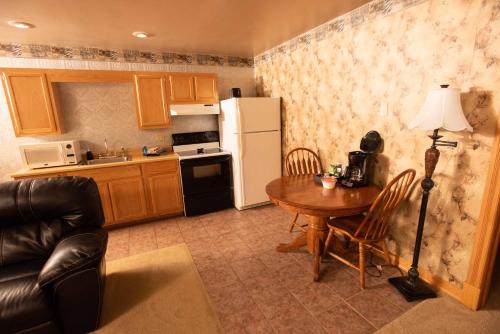 a kitchen with a table and a white refrigerator at Blue Spruce Motel in Massena