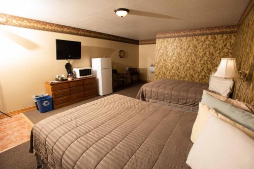 a hotel room with two beds and a flat screen tv at Blue Spruce Motel in Massena