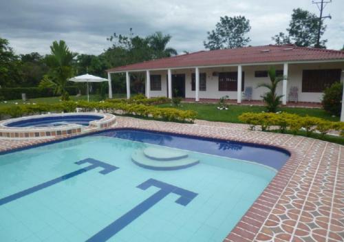 una piscina di fronte a una casa di Finca Campestre con Piscina en Villavicencio a Granja El Hachón