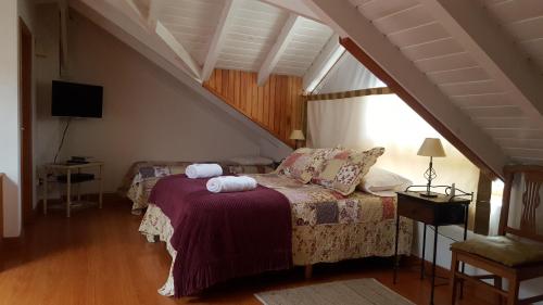 1 dormitorio con 1 cama con 2 toallas en Estadía Del Bosque en San Martín de los Andes