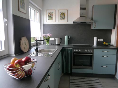 a kitchen with a sink and a bowl of fruit on the counter at Kunst und Meer in Varel