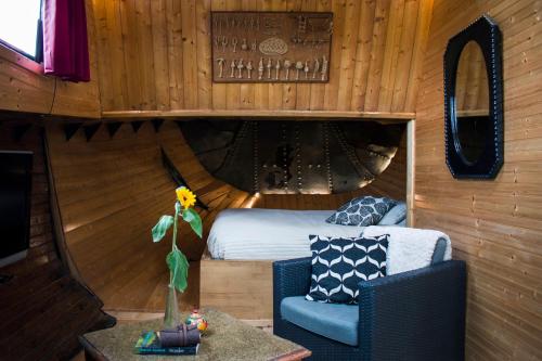 a bedroom with a bed and a chair and a table at Houseboat Vinkeveen in Vinkeveen