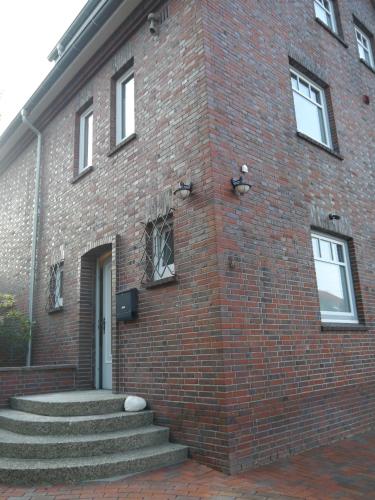 a brick building with stairs leading up to a door at Kunst und Meer in Varel