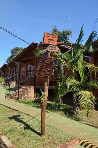 a pole with signs in front of a building at Terra Iguazú Cabañas in Puerto Iguazú