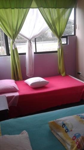 a bedroom with two beds with green drapes at Casa Huespedes El Molino in Tababela