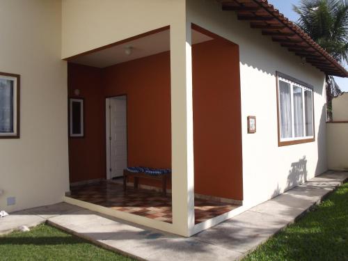 une terrasse couverte à l'avant d'une maison avec une porte ouverte dans l'établissement Solar do Jenipapo, à Tamoios