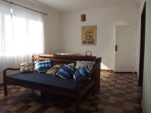 Cette chambre comprend un banc avec des oreillers et une fenêtre. dans l'établissement Solar do Jenipapo, à Tamoios
