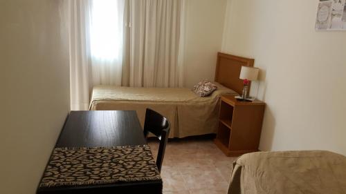 a small room with a table and a bed and a window at La Casona in Federación