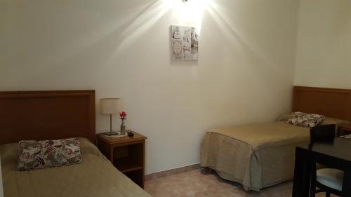 a bedroom with two beds and a table with a lamp at La Casona in Federación