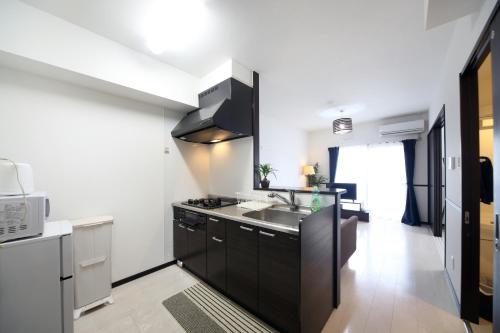 a kitchen with a sink and a microwave at EX Itoman Apartment 203 in Itoman