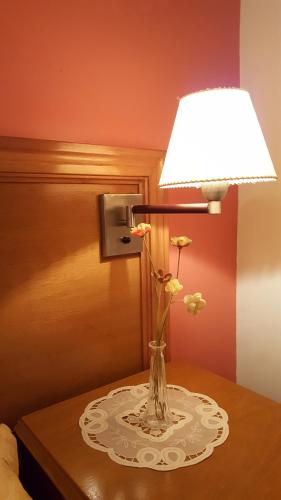 a vase with flowers on a table with a lamp at La Casona in Federación