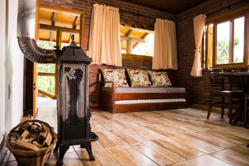 a living room with a couch and a stove at Ninho das Águias Cabana in Nova Petrópolis