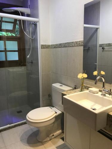 uma casa de banho com um WC, um lavatório e um chuveiro em Apto incrível em condomínio lindo na Praia do Forte
