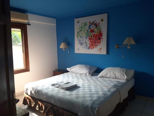 a bedroom with a bed with a blue wall at Maven Buncit in Jakarta